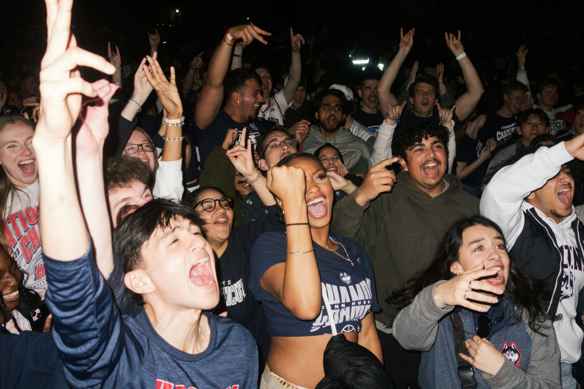 a large group of people are cheering at a concert